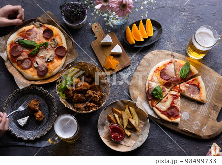 ピザとビールを楽しむテーブル 98499733