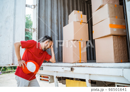 male delivery worker in red shirt tired with cardboard boxes 98501641