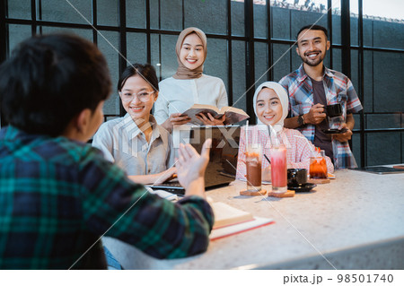 young people pay attention to explanation of friends who talk 98501740