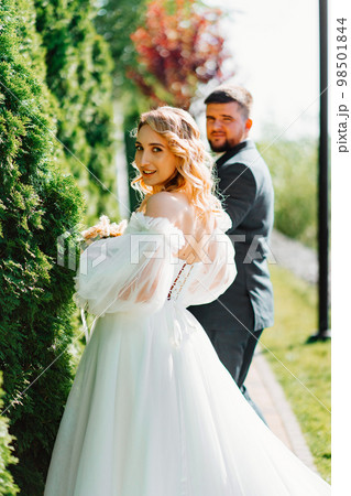 the groom leads the bride by the hand along the path.  98501844