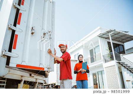 delivery workers standing near container door against white building background delivery workers standing near container door against white building background 98501999