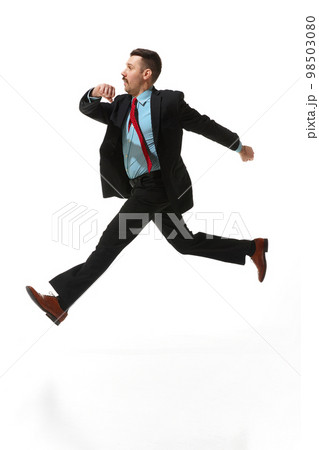 Businessman in a suit with positive mood walking to work over white studio background. Reaching goals. Concept of business, career, innovations, ad Businessman in a suit with positive mood walking to work over white studio background. Reaching goals. Concept of business, career, innovations, ad 98503080