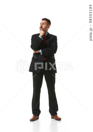 Businessman in a suit standing with thoughtful serious face over white studio background. Working day. Concept of business, career, innovations, ad 98503184