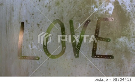 Word L O V E painted on a misted window. Symbol of love drawn on the glass. Word L O V E painted on a misted window. Symbol of love drawn on the glass. 98504413