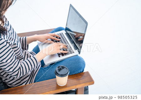 白い明るいリビングでパソコンで作業する女性の手元 白い明るいリビングでパソコンで作業する女性の手元 98505325