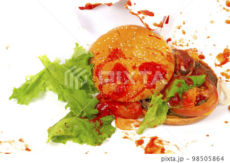 Broken hamburger against the background of splashed ketchup.Creative hamburger. Broken hamburger against the background of splashed ketchup.Creative hamburger. 98505864