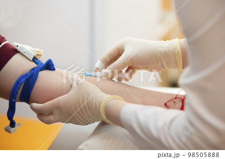 The doctor makes an injection into the patient's vein. The doctor makes an injection into the patient's vein. 98505888