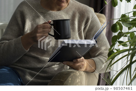 Closeup image of a beautiful young asian woman holding and reading book 98507461