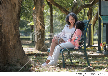 Asian Grandmother and Granddaughter hug together outdoor park. Hobbies and leisure, lifestyle, family life, happiness moment concept 98507475