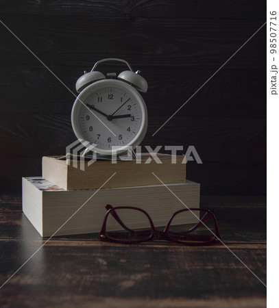White retro style clock on brown wooden background White retro style clock on brown wooden background 98507716