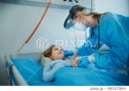 Friendly woman doctor taking care and playing with little girl. 98507864