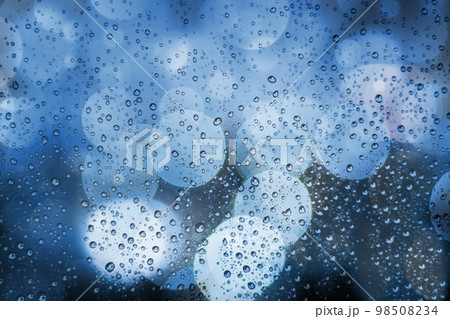 Abstract background with raindrops and soft blue bokeh. Defocused lights and water droplets on rainy wet window. Street bokeh lights out of focus. Rainy days, weather concept. View through window 98508234