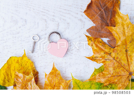 Love message in autumn leaves. Clean notebook and heart-shaped lock on white background. Copyspace. 98508503