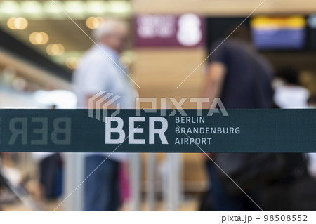 Close-up detail view of BER code Berlin Brandenburg airport logo security barrier tape divider ribbon inside new terminal building. German capital IATA sign. Trade union strike flight cancellation 98508552