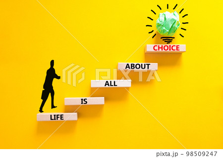 Choice and life symbol. Concept words Life is all about choice on wooden blocks. Beautiful yellow table yellow background. Businessman icon. Business choice and life concept. Copy space. 98509247