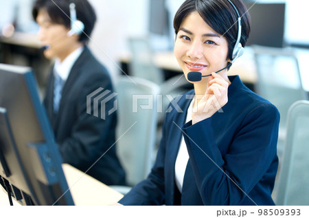 オフィスでヘッドセットをつけて対応するオペレーターの女性 98509393