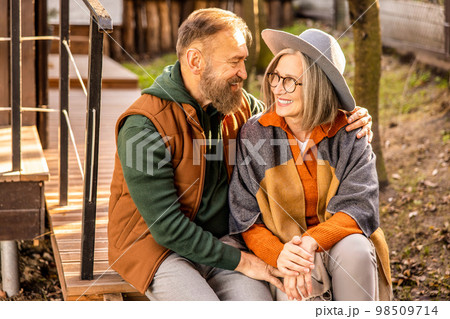 Man and woman sitting close and looking in love 98509714