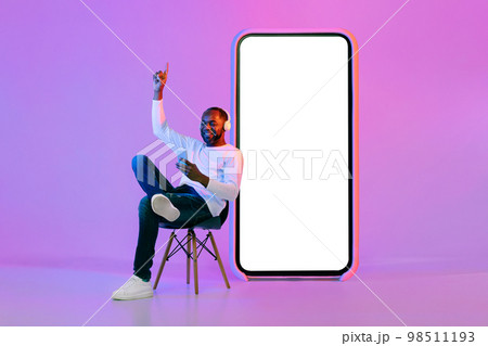 Cheerful african american man using smartphone and wireless headphones, mockup 98511193