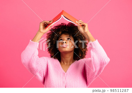 Serious millennial african american curly female student in casual lifts book up, reads diary, look up Serious millennial african american curly female student in casual lifts book up, reads diary, look up 98511287