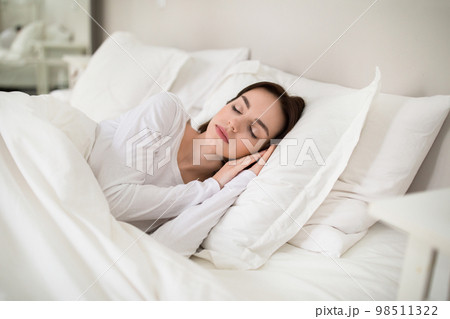 Beautiful young woman sleeping with hands under her head 98511322