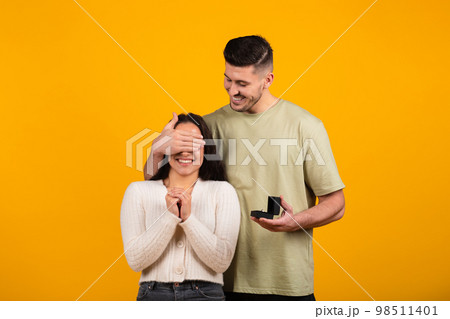 Happy millennial tall arab guy close eyes to amazed woman, hold box with ring 98511401
