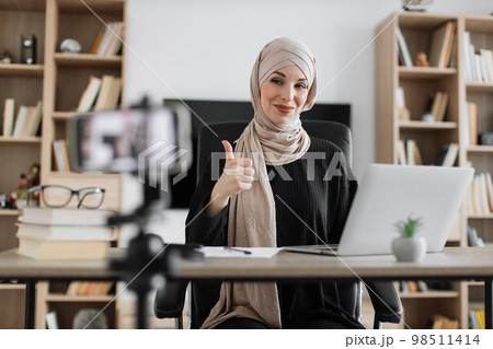 Female tutor working at home during distance learning and showing thumb up. 98511414