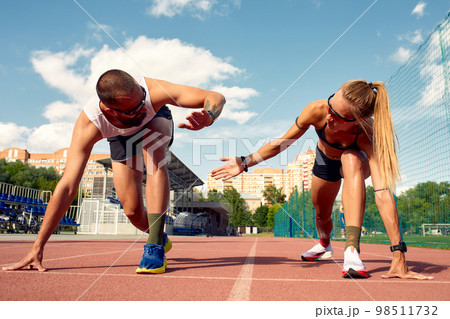 Man and woman at the start of the treadmill at the stadium Man and woman at the start of the treadmill at the stadium 98511732