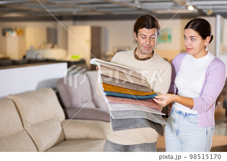 Happy man and woman choosing wooden furniture in furniture showroom Happy man and woman choosing wooden furniture in furniture showroom 98515170