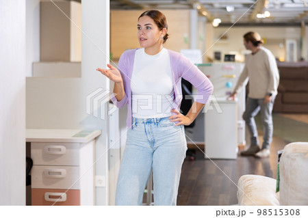 girl is in furniture store and imagines how the new furniture will look in her house 98515308