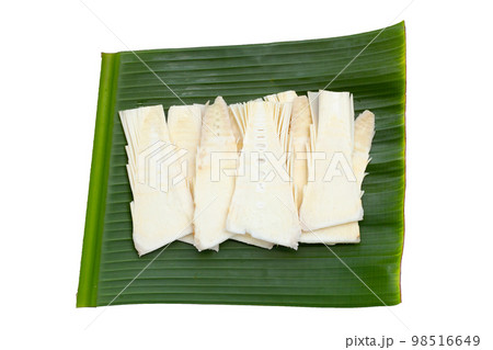 Sliced raw bamboo shoots on banana leaf on white background. 98516649