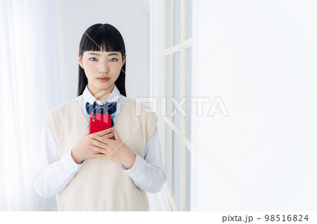 スマホを持つ女子学生 98516824