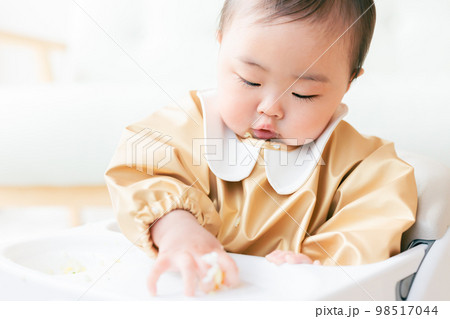 離乳食を手づかみ食べするカミカミ期の赤ちゃん 離乳食を手づかみ食べするカミカミ期の赤ちゃん 98517044