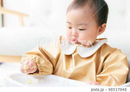 離乳食を手づかみ食べするカミカミ期の赤ちゃん 離乳食を手づかみ食べするカミカミ期の赤ちゃん 98517048