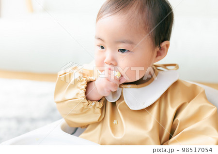 離乳食を手づかみ食べするカミカミ期の赤ちゃん 98517054