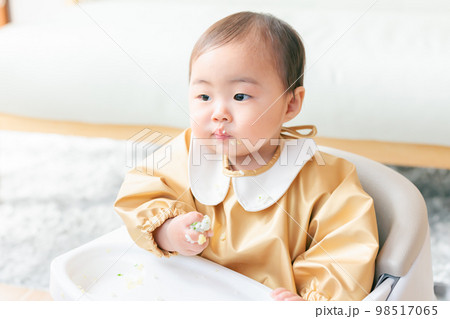 よそ見しながら食べる赤ちゃん 98517065