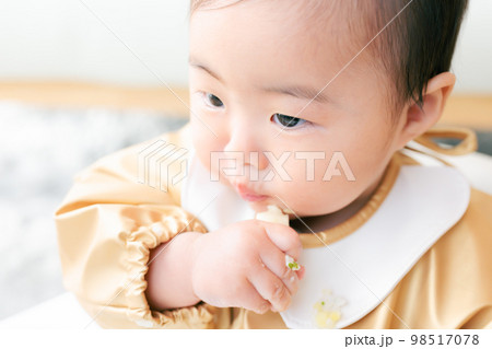 離乳食を手づかみ食べするカミカミ期の赤ちゃん 98517078