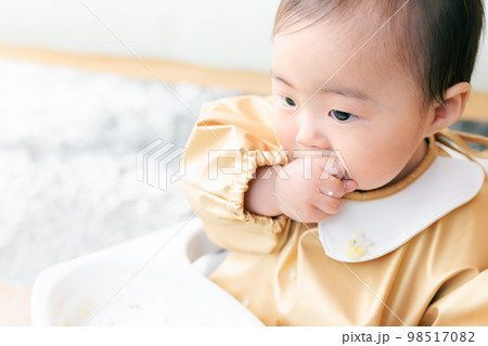 離乳食を手づかみ食べするカミカミ期の赤ちゃん 離乳食を手づかみ食べするカミカミ期の赤ちゃん 98517082