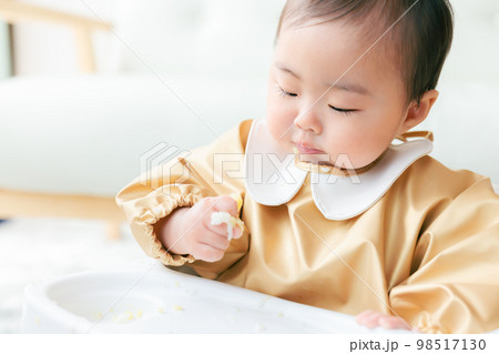 離乳食を手づかみ食べするカミカミ期の赤ちゃん 離乳食を手づかみ食べするカミカミ期の赤ちゃん 98517130
