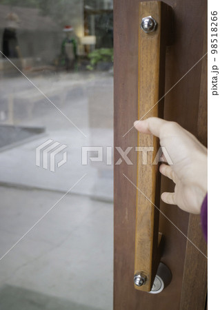 Woman opens the door holding the handle 98518266