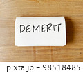 デメリット（Demerit）とペンで書かれたノート 98518485