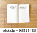 メリットデメリット（Merit  Demerit）とペンで書かれたノート 98518488