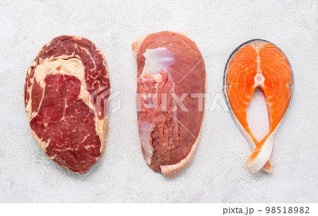 Steak concept with salmon  steak, rib eye steak and duck breast set up on white concrete background. 98518982