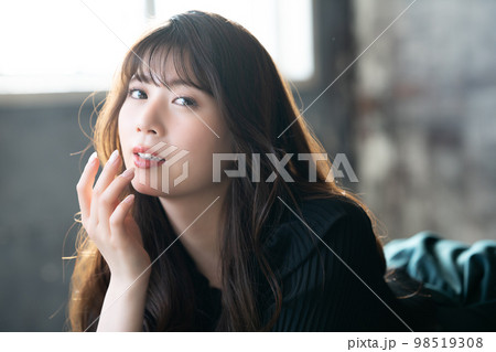 寝転んで寛ぐオシャレな若い女性 98519308