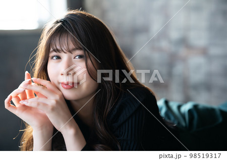 寝転んで寛ぐオシャレな若い女性 98519317
