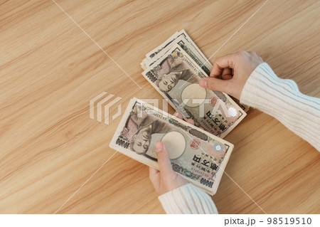 Woman hand counting Japanese Yen banknote over table background. Thousand Yen money. Japan cash, Tax, Recession Economy, Inflation, Investment, finance, savings, salary and payment concepts Woman hand counting Japanese Yen banknote over table background. Thousand Yen money. Japan cash, Tax, Recession Economy, Inflation, Investment, finance, savings, salary and payment concepts 98519510