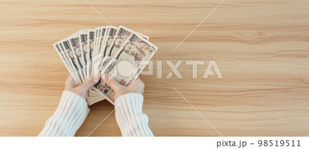Woman hand counting Japanese Yen banknote over table background. Thousand Yen money. Japan cash, Tax, Recession Economy, Inflation, Investment, finance, savings, salary and payment concepts Woman hand counting Japanese Yen banknote over table background. Thousand Yen money. Japan cash, Tax, Recession Economy, Inflation, Investment, finance, savings, salary and payment concepts 98519511