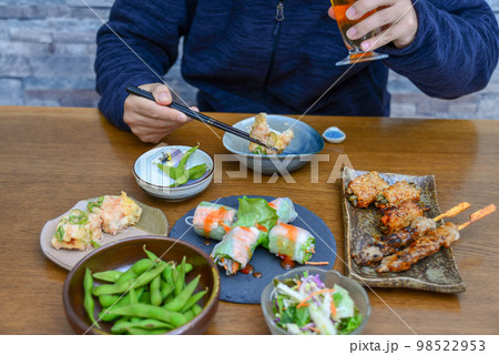 ビールを片手に飲み食いする人の姿 ビールを片手に飲み食いする人の姿 98522953