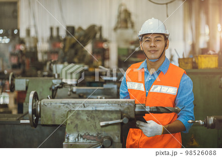 portrait Asian engineer adult male worker in machine shop with check list happy smile in safety hardhat portrait Asian engineer adult male worker in machine shop with check list happy smile in safety hardhat 98526088