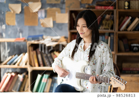 ギターを弾く若い女性 98526813