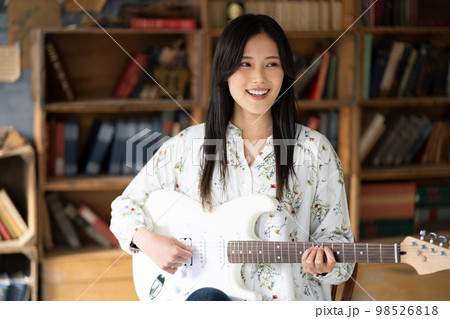 ギターを弾く若い女性 98526818